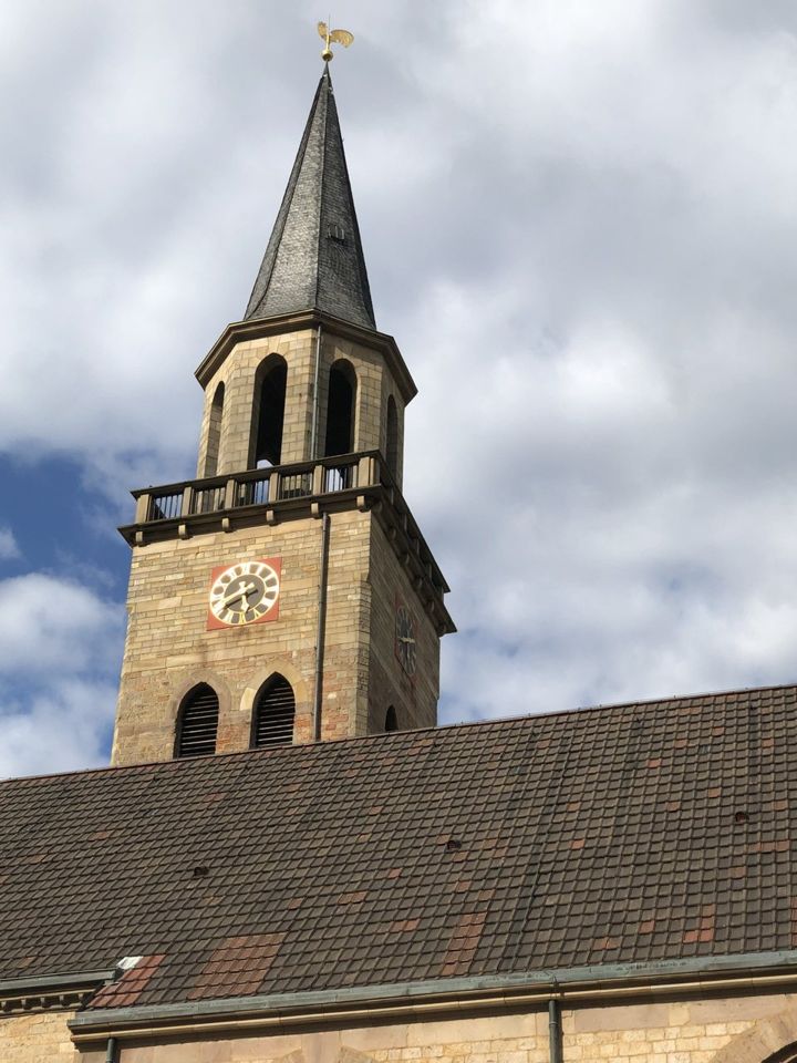Der Sandsteinturm der Pauluskirche mit Uhr und schiefergedecktem Spitzhelm